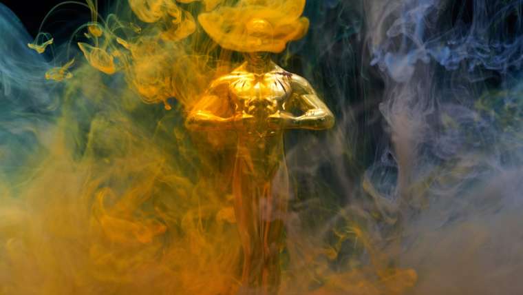 Statuette de la cérémonie des oscars entourée de fumée gold et blanche
