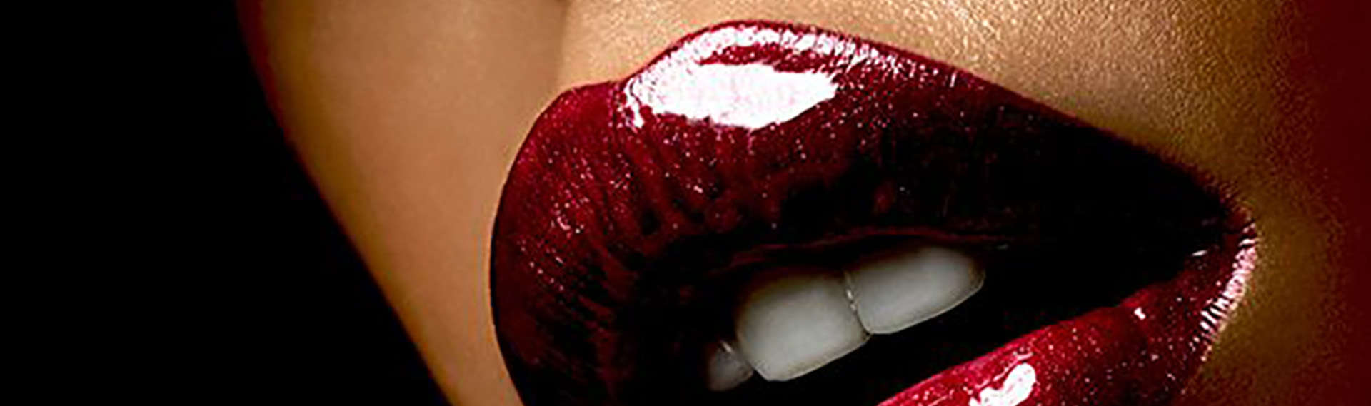 Gros plan sur une bouche laquée d'un rouge presque grappe de raisin