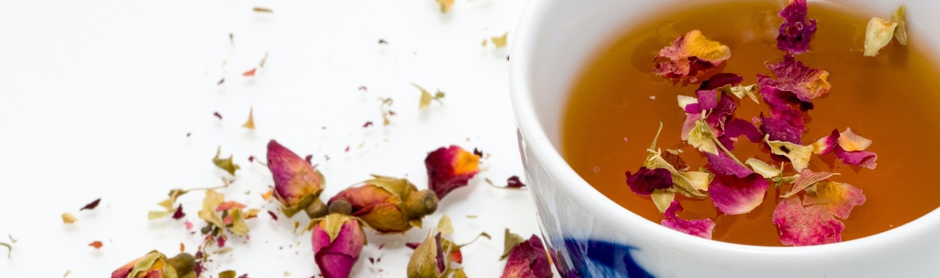 bol de thé avec des boutons de roses à la surface du breuvage