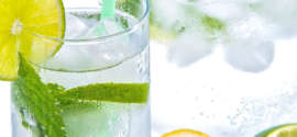 Citronnade à boire en cure detox servie dans un verre à long drink décoré de menthe et de rondelles de citrons jaunes